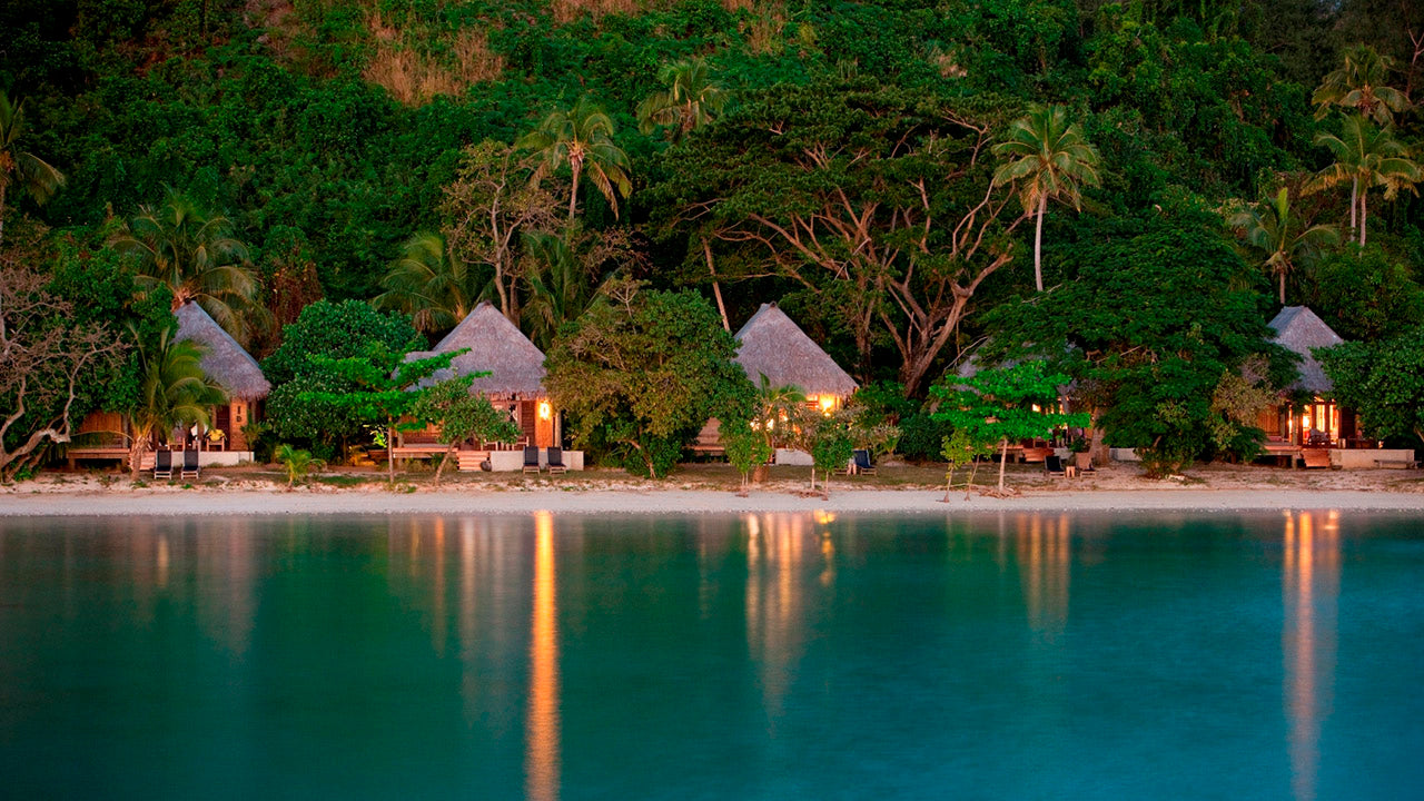 Likuliku Lagoon Resort beachfront bures at dusk